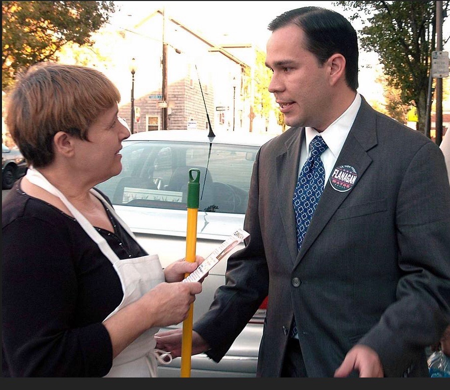 Will Flanagan speaking with a Fall River shopkeeper on the street