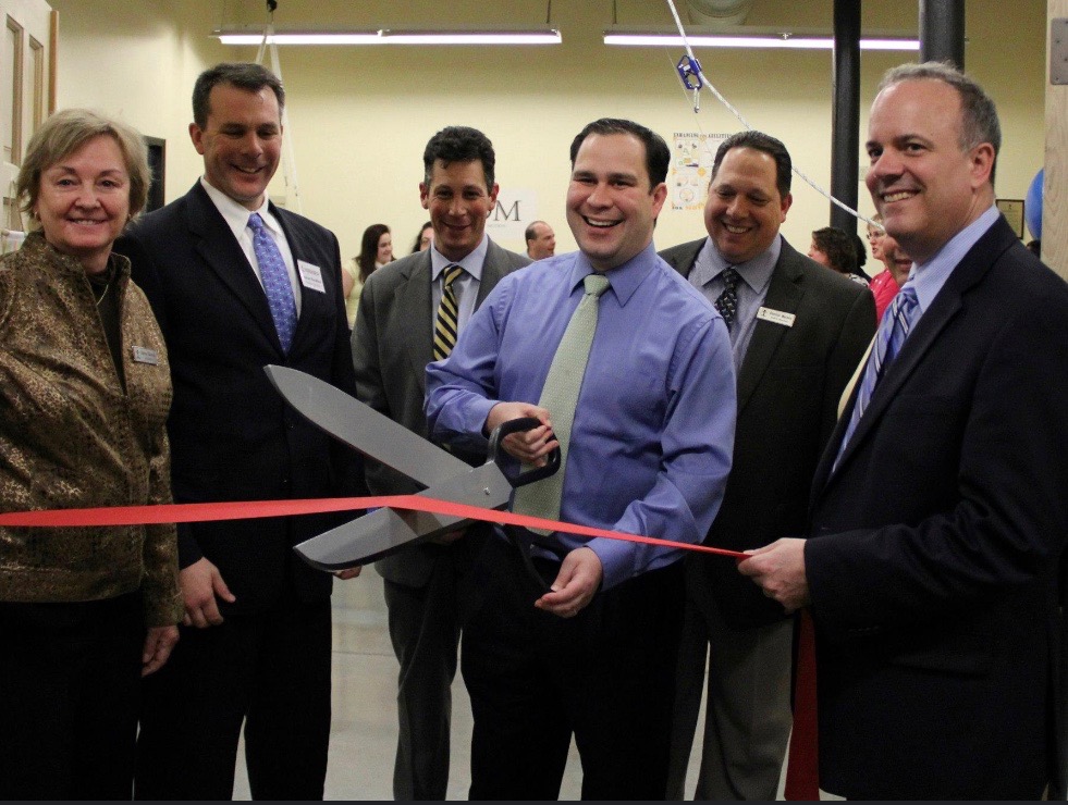 Will Flanagan cuts a red ribbon at a Fall River grand opening
